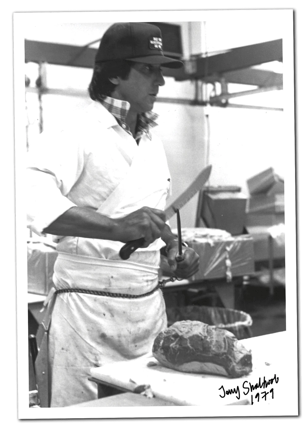 A black-and-white family photograph of our grandfather working as a butcher