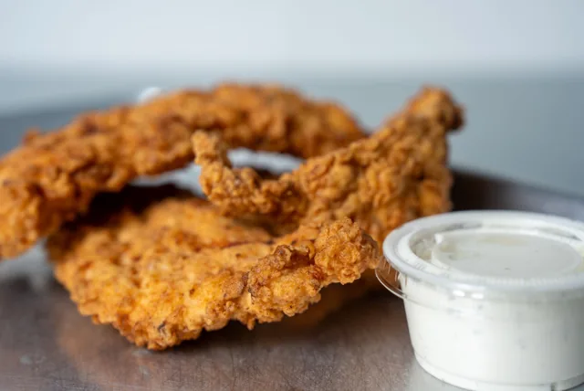 Crispy chicken tenders served with dipping sauce