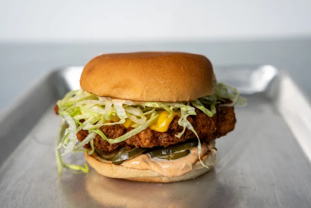 A crispy chicken sandwich with lettuce and pickles