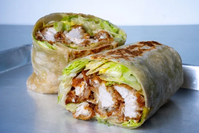 A chicken Caesar wrap cut open to show the filling