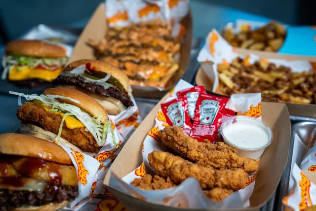A table filled with burgers, chicken tenders and sides