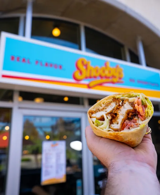 A chicken wrap in front of the Shooby’s storefront
